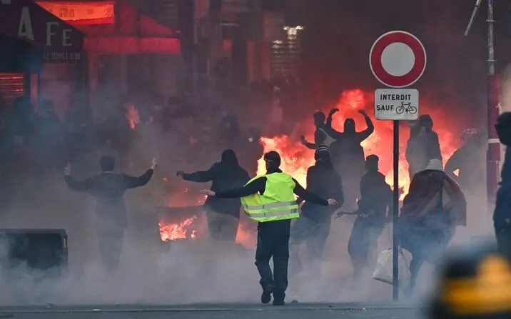 Scène de rue avec fumée et incendie au milieu de personnes présentes