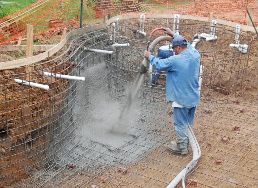 Professionnel projetant du béton dans une structure de piscine