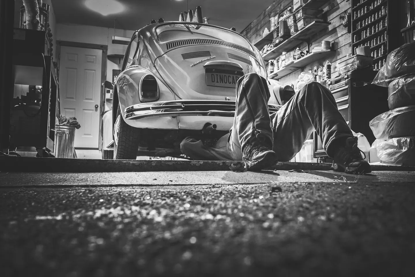 Entretien d'une voiture dans un atelier, photographie en noir et blanc
