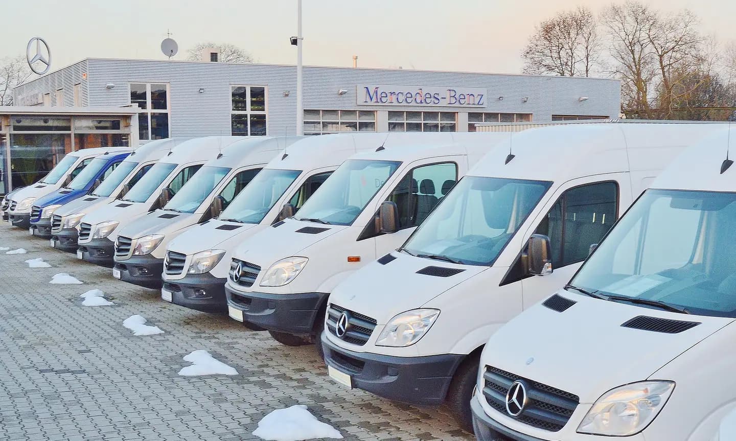 Flotte de véhicules utilitaires stationnée sur un parc professionnel